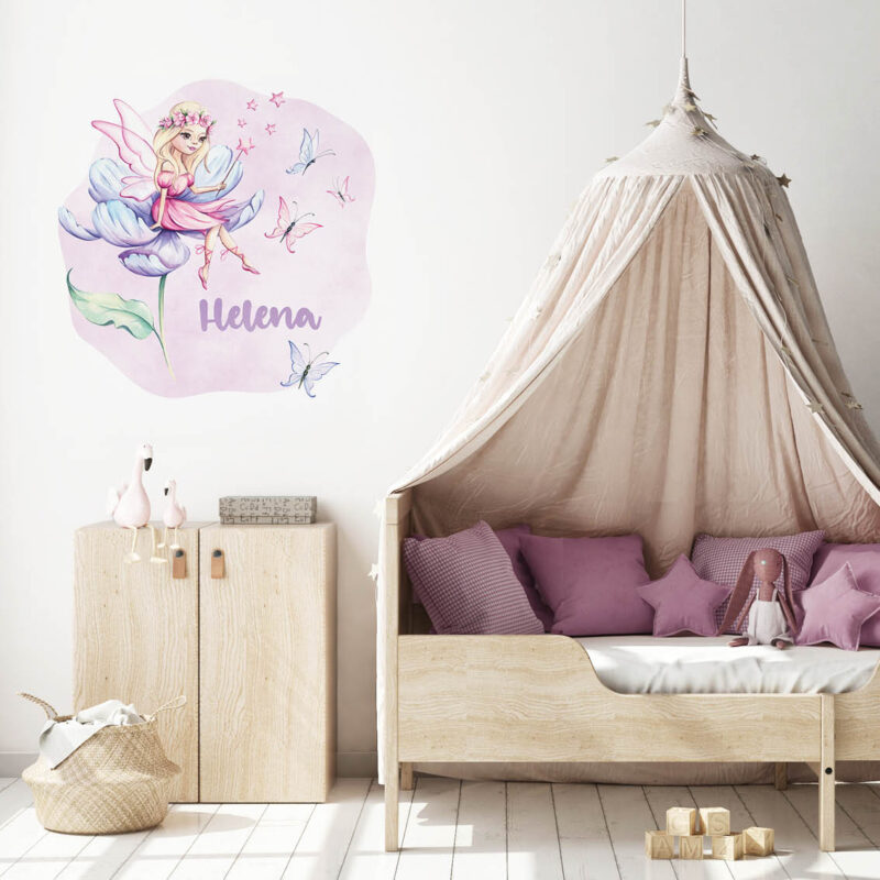 Personalizirana dječja naljepnica za zid s imenom i ilustracijom vile koja sjedi na cvijetu, okružena leptirima i zvjezdicama u ljubičastim tonovima.